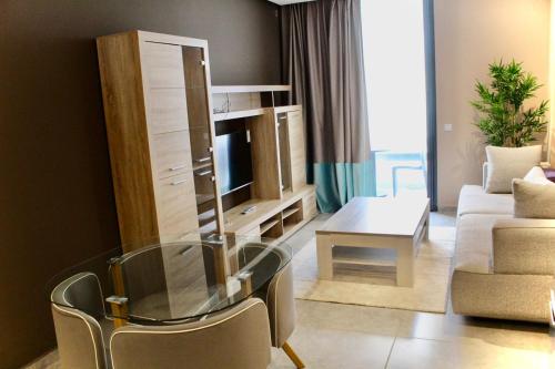 a living room with a glass table and a television at Atlas-Résidence by Rent-Inn in Rabat
