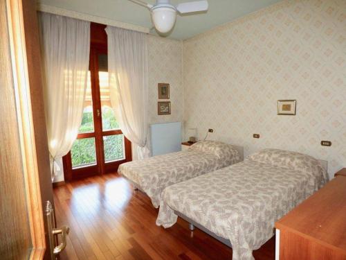 a bedroom with two beds and a window at Villa Lidia, Como Lake in Colico