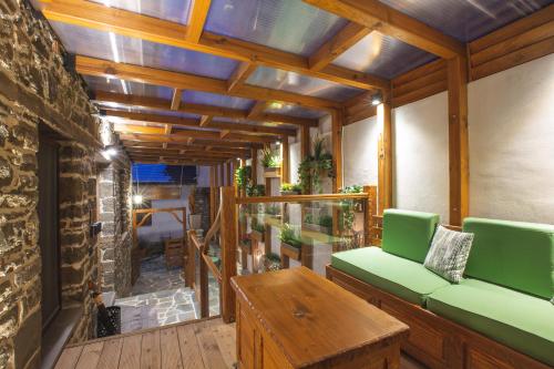 a living room with a green couch and a table at Adryades luxury apartments in Metsovo