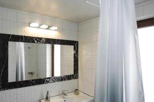 a bathroom with a shower curtain and a sink and a mirror at Holiday complex, Swinoujscie in Świnoujście