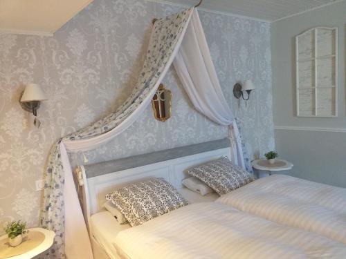 a bedroom with a canopy bed with two pillows at Ancien Domain "Le petit Bonheur" in Tailly