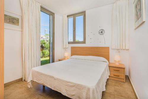 a bedroom with a bed and a large window at Molins 5 in Cala de Sant Vicent
