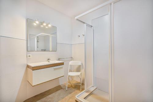 La salle de bains est pourvue d'un lavabo et d'une douche en verre. dans l'établissement Molins 5, à Cala Sant Vicenç