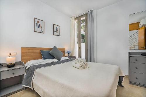 1 dormitorio con 1 cama con 2 toallas en MOLINS 4, en Cala de Sant Vicent