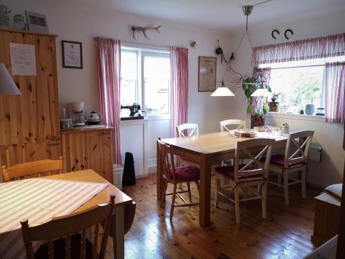 a dining room with a wooden table and chairs at Elvebakk Bed & Breakfast in Reed