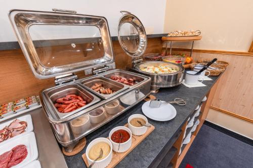 um balcão de cozinha com muitas bandejas de comida em Wellness Hotel IRIS em Pavlov