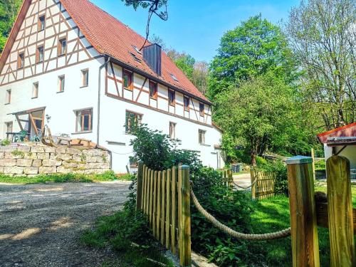 una gran casa blanca con una valla de madera en Fasshotel Westernwagen, beheizt 2-3 Personen, en Kirchensittenbach