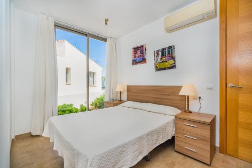 1 dormitorio con cama y ventana grande en MOLINS 2, en Cala de Sant Vicent