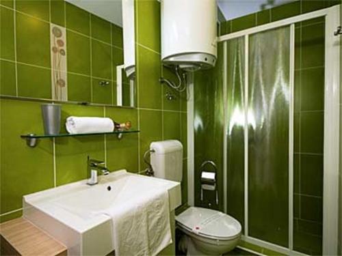 a green bathroom with a sink and a toilet at Apartments Twins in Herceg-Novi