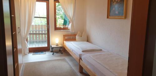 1 dormitorio con 2 camas y ventana en Burgauer Hof, en Burgau