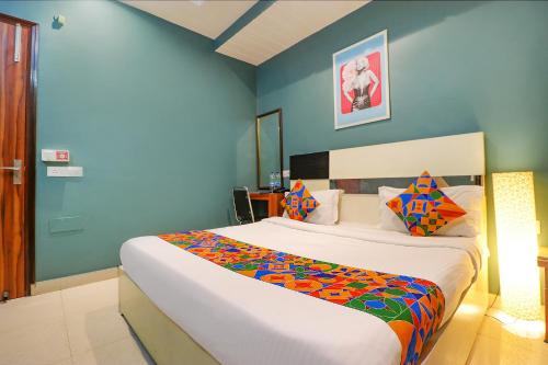 a bedroom with a large bed with a colorful blanket at FabHotel Church House Rohini in New Delhi