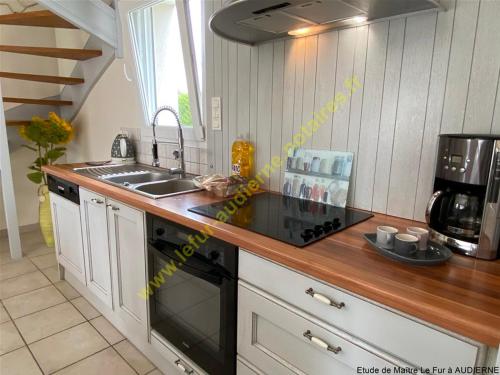 une cuisine avec un évier et une cuisinière four supérieur dans l'établissement MAISON DE VACANCES, A 150 m de la Mer, à Plouhinec