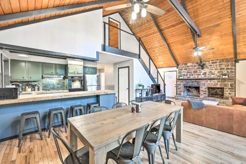 an open kitchen and dining room with a wooden table and chairs at Game Room, Fire Pit and Deck Spacious Poconos Home! in Lake Harmony