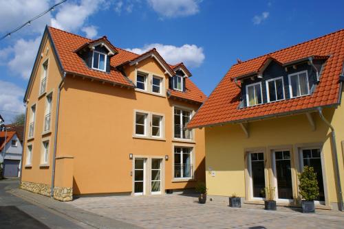 a yellow house with an orange roof at Gästehaus Reßler in Harxheim