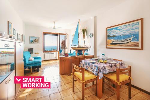 a dining room with a table and a sailboat on the wall at Una terrazza sul golfo di Ospedaletti by Wonderful Italy in Ospedaletti