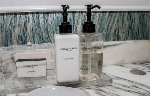 two bottles of soap sitting on top of a bathroom counter at Sandals Guest House in Durban
