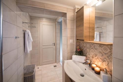 a bathroom with a tub and a sink with candles at The Beach House-Valley of love in Episkopos