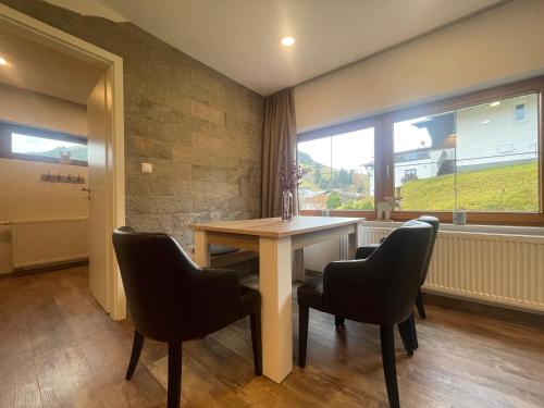 a dining room with a table and chairs and a window at Bergquell Tirol in Jungholz
