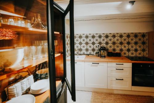 uma cozinha com armários brancos e azulejos pretos e brancos em Casa Corner em Vrsar