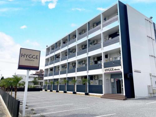 a large white building with a sign in front of it at HYGGE Biimata in Nago