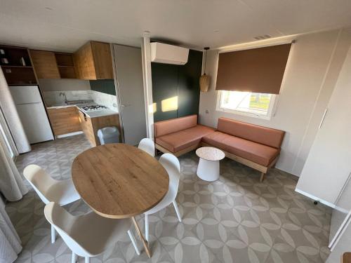 Camping LES PEUPLIERS في هييريس: غرفة معيشة صغيرة مع طاولة وأريكة