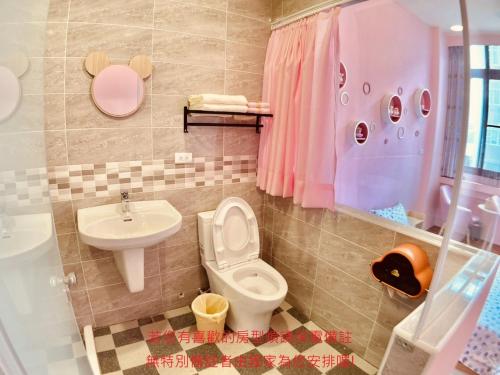 uma casa de banho com um WC e um lavatório em Green Only Homestay em Tainan