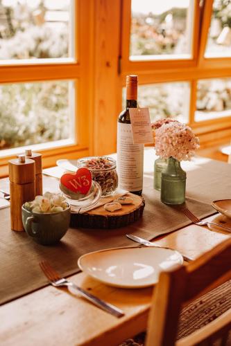 a table with a bottle of wine and flowers on it at Weingut Kollerhof am Eichberg in Leutschach