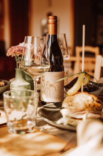 a bottle of wine sitting on a table with glasses at Weingut Kollerhof am Eichberg in Leutschach