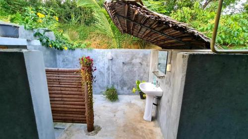 a bathroom with a sink next to a wall at Serendipity (Weligama) in Weligama