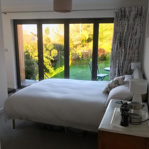 a large bed in a room with a large window at Uplands Garden in Morecombelake