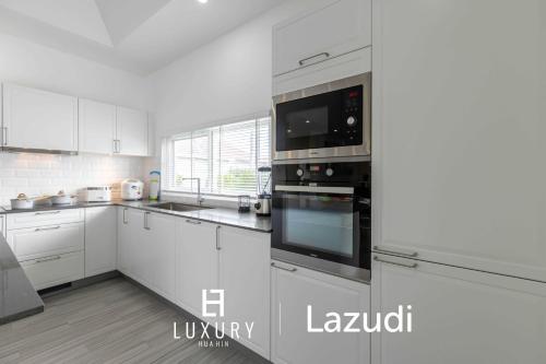 a white kitchen with white cabinets and appliances at New Modern 3 Bedroom Pool Villa MS24 in Hua Hin