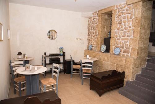 un restaurante con mesas y sillas y una pared de piedra en La Lanterna Di BaChi, en Sciacca