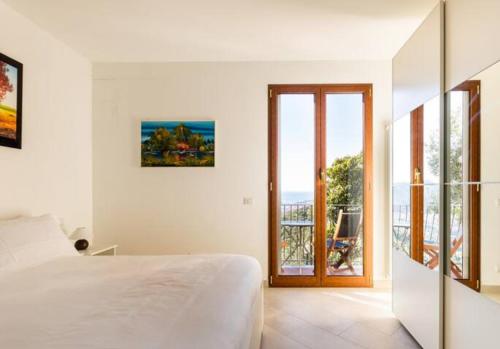 Un dormitorio blanco con una cama y un balcón. en Il Glicine, en Sestri Levante