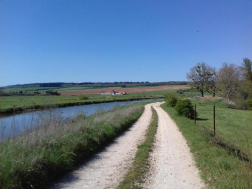a dirt road next to a river at Gîte Tante Aurore et chambres d'Hôtes in Chémery