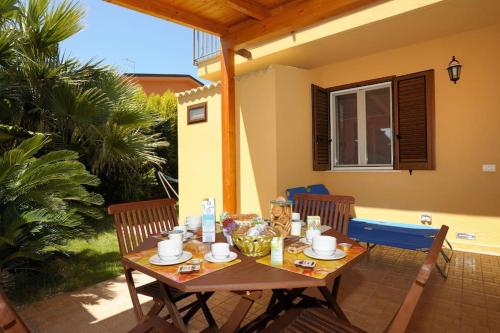 a wooden table and chairs on a patio at Villa Rosa in Porto Empedocle