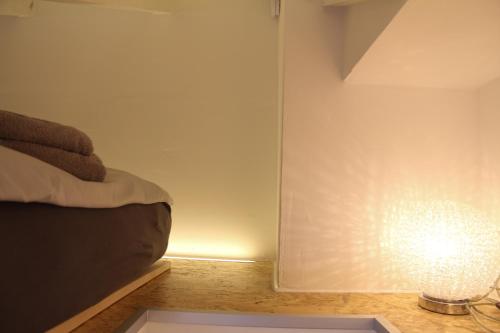 a room with a bed and a lamp next to a wall at gemütliches tiny apartment - nur 10min vom Zentrum in Stuttgart