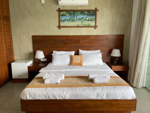a bedroom with a large bed with towels on it at Lotus Lake Residence in Kandy