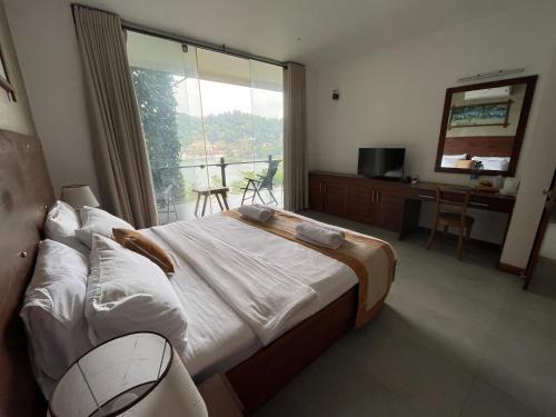 a bedroom with a large bed and a balcony at Lotus Lake Residence in Kandy