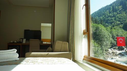 a bedroom with a window with a view of a mountain at Ayder Hasimoglu Hotel in Ayder Yaylasi