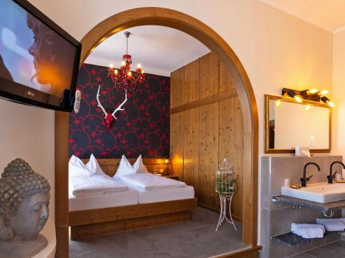 a bathroom with a bed and a sink and a mirror at Hotel Ertl & Restaurant EL Venado in Spittal an der Drau
