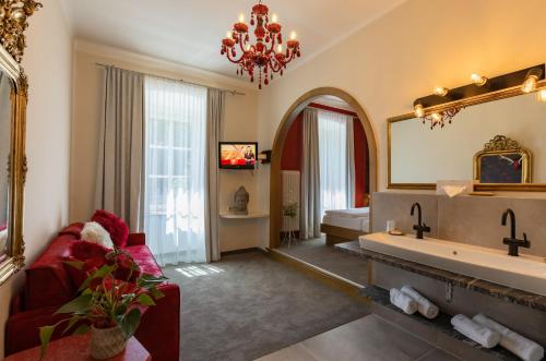 ein großes Bad mit einem großen Spiegel und einer Badewanne in der Unterkunft Hotel Ertl & mexican cantina salud in Spittal an der Drau