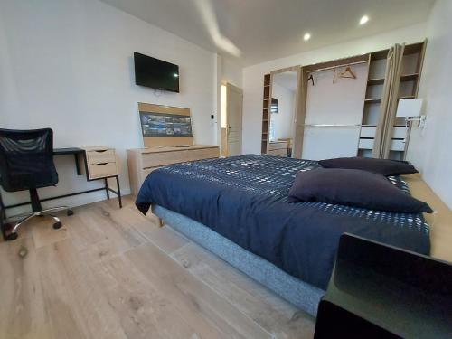 Dormitorio con cama, escritorio y TV en Superbe appartement au centre de St Jorioz, en Saint-Jorioz