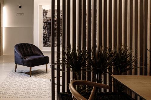 a room with a chair and a table and plant at Amery House in Sliema