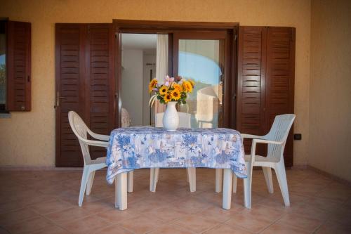 a table with a vase of flowers on it at Ville del Mar in San Teodoro