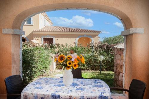 a vase of sunflowers sitting on a table at Ville del Mar in San Teodoro