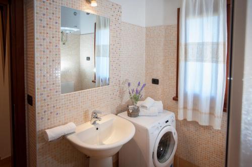 a bathroom with a washing machine and a sink at Ville del Mar in San Teodoro