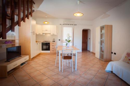 a kitchen and living room with a table and chairs at Ville del Mar in San Teodoro