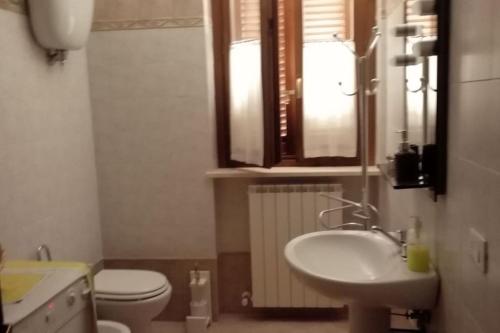 een badkamer met een wastafel, een toilet en een raam bij Casa-Vacanze I Vecchi Valori Umbria in Capodacqua di Foligno