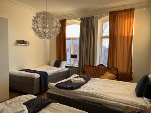 a hotel room with two beds and a chandelier at Frövi hotell in Frövi