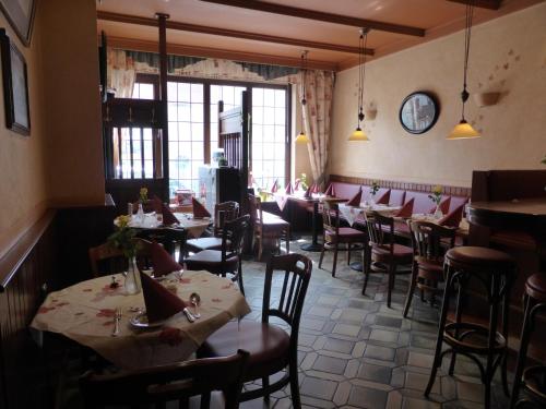 a restaurant with tables and chairs in a room at Zwehrener Hof in Kassel